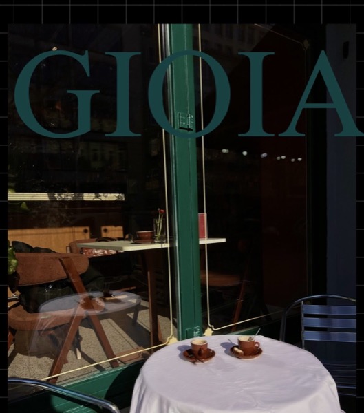 Das Schaufenster mit dem grünen Schriftzug Gioia, davor ein Bistrotisch mit zwei Espressotassen.