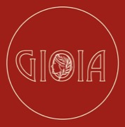 Das Signet der Bar: der Schriftzug GIOIA in einem Kreis, das mittlere O ist ein Frauenprofil mit Lorbeerzweig.